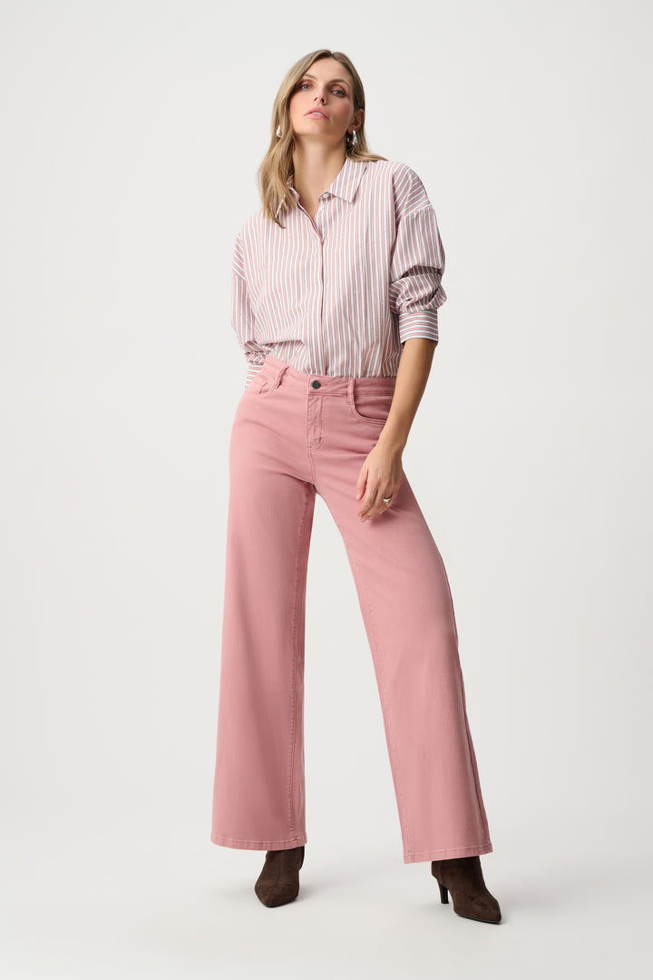 Woman wearing a pink striped shirt and pink pants on a white background
