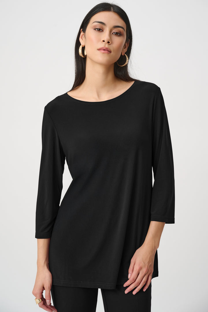 Woman wearing a black long-sleeve top against a white background