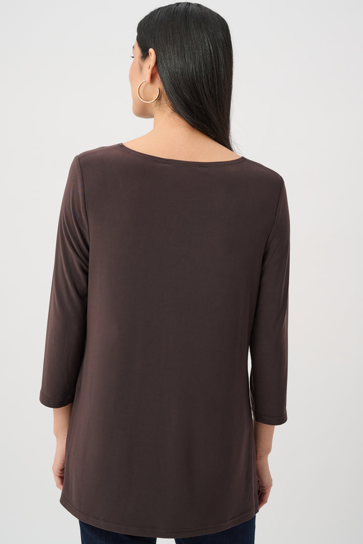 Woman wearing a brown long-sleeve top on a white background