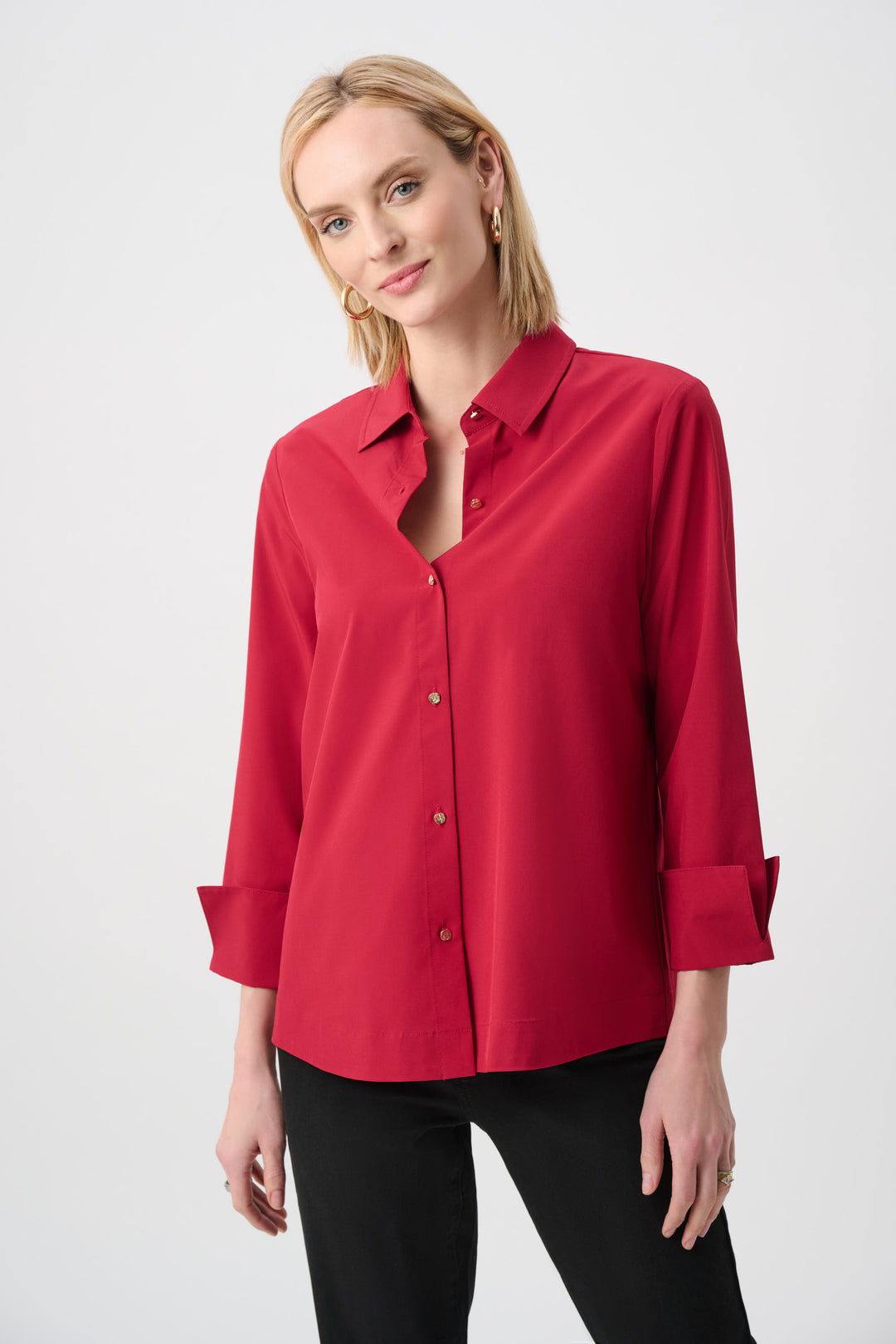 Woman wearing a red blouse with rolled-up sleeves on a white background