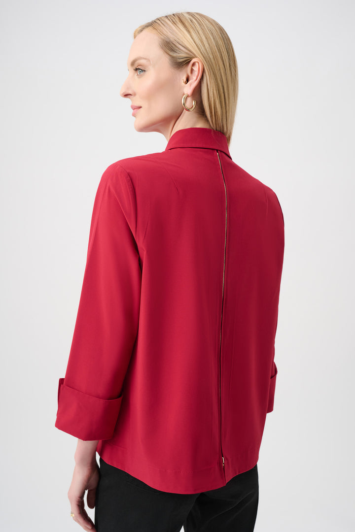 Woman wearing a red blouse against a white background