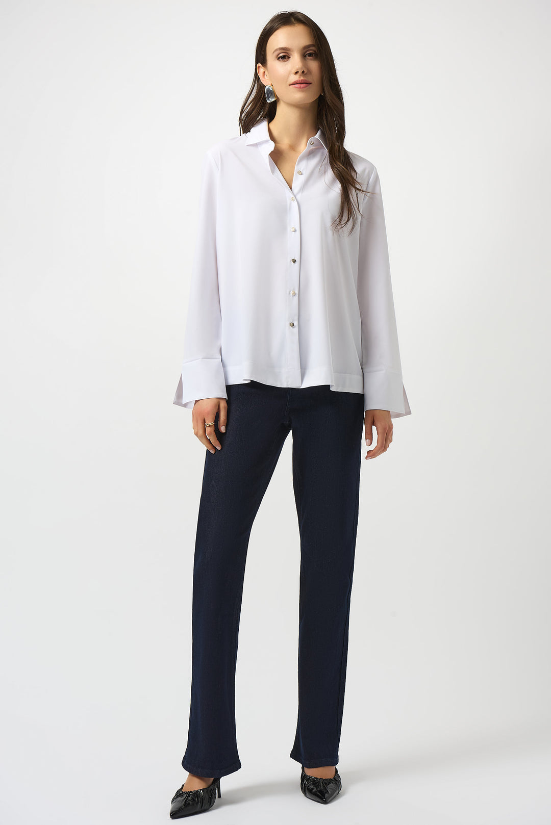 Woman wearing a white shirt and dark pants on a white background