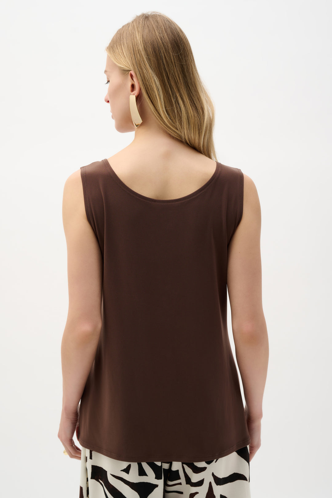 Woman wearing a brown sleeveless top on a white background