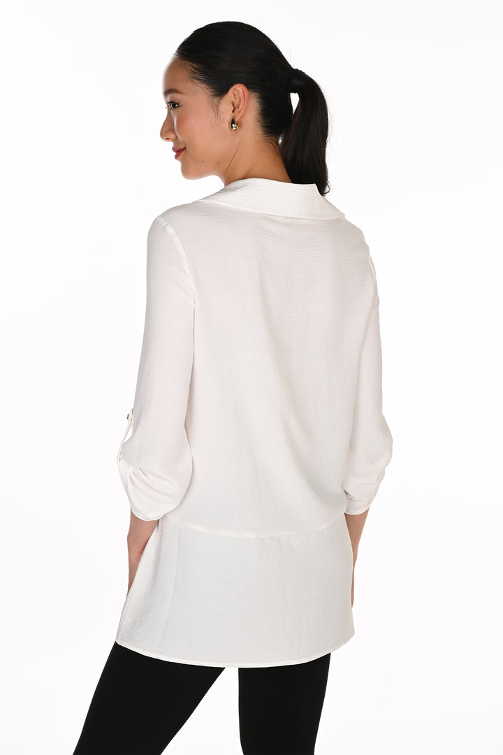 A woman shown from the back wearing a white long-sleeve collared blouse with black pants, photographed against a plain white studio background.