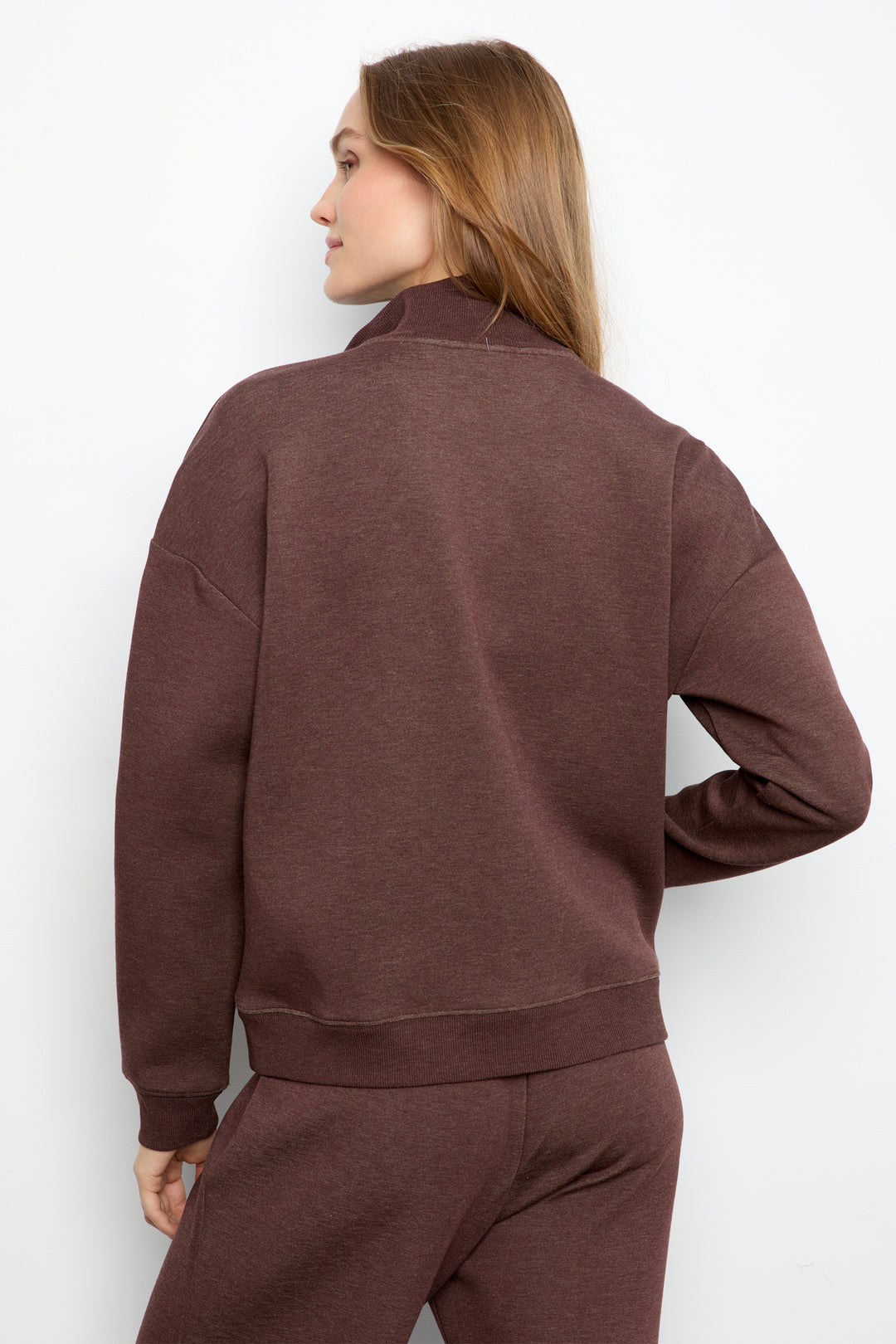 A woman shown from the back wearing a heathered brown long-sleeve sweatshirt and matching sweatpants against a plain white background.