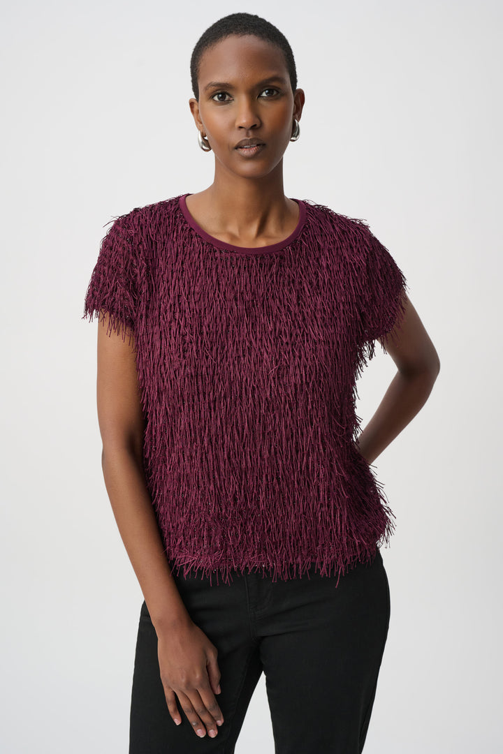 Woman wearing a textured purple top against a white background