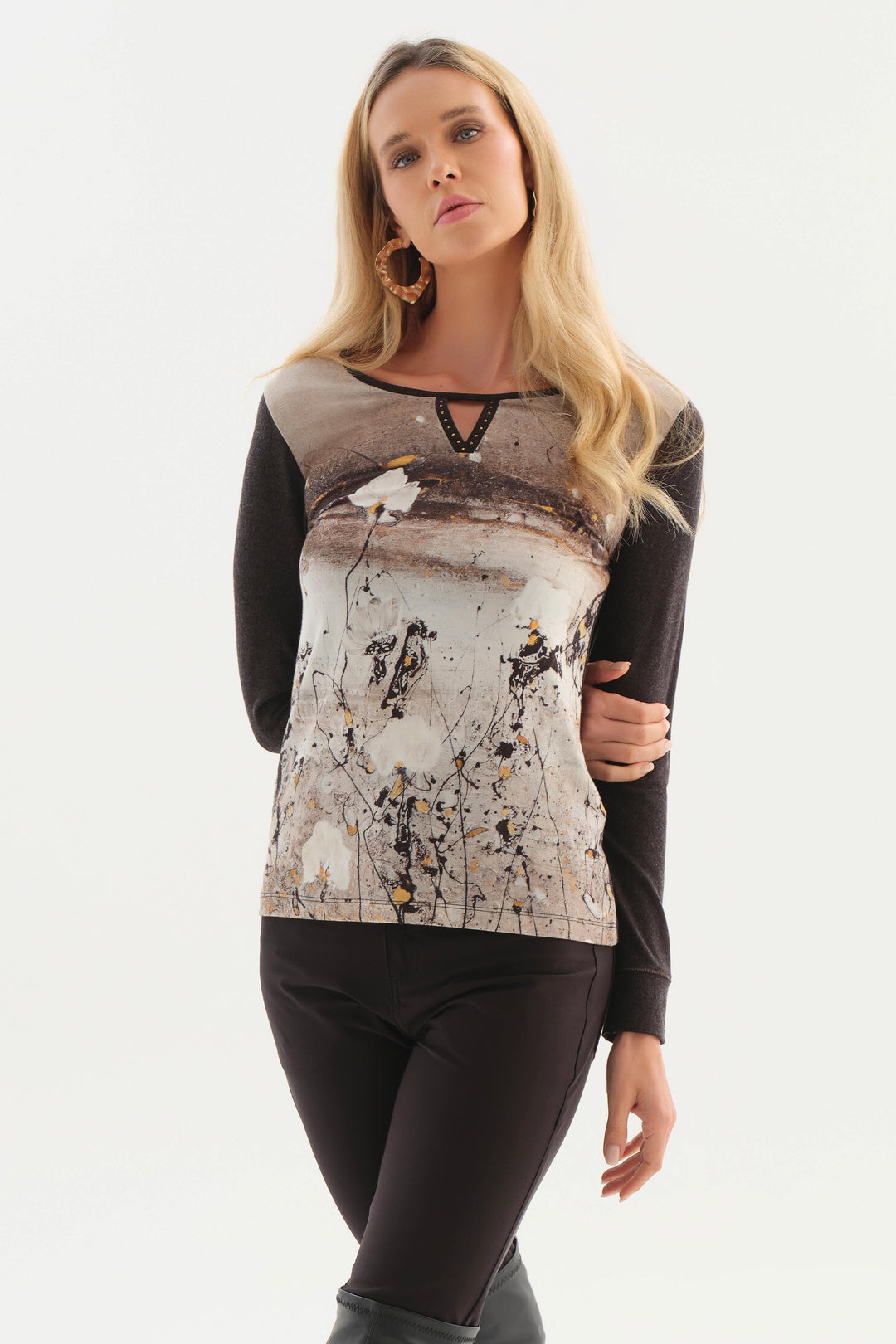 A women modelling a long sleeve top with black back and sleeves, white and brown pattern on the front shown from the side in front of a white background. 