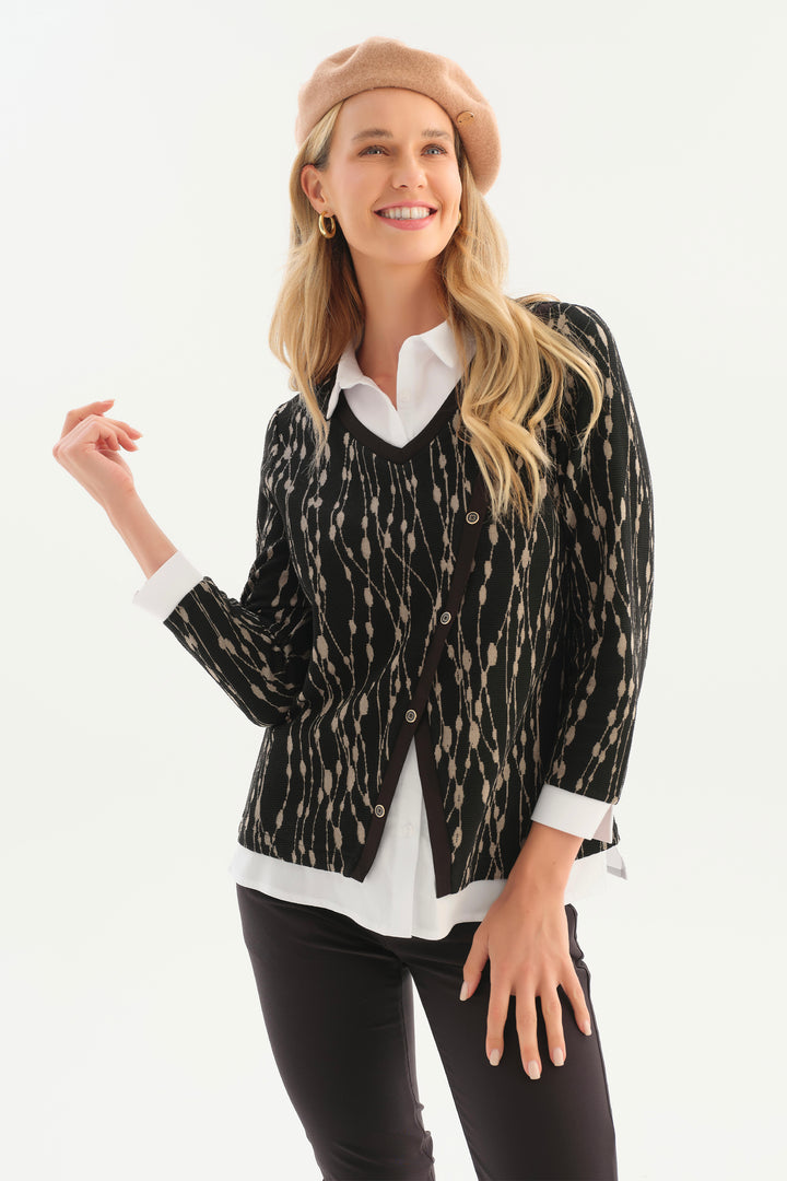 A women modelling a long sleeve top with white collar and black and taupe print in front of a white background. 