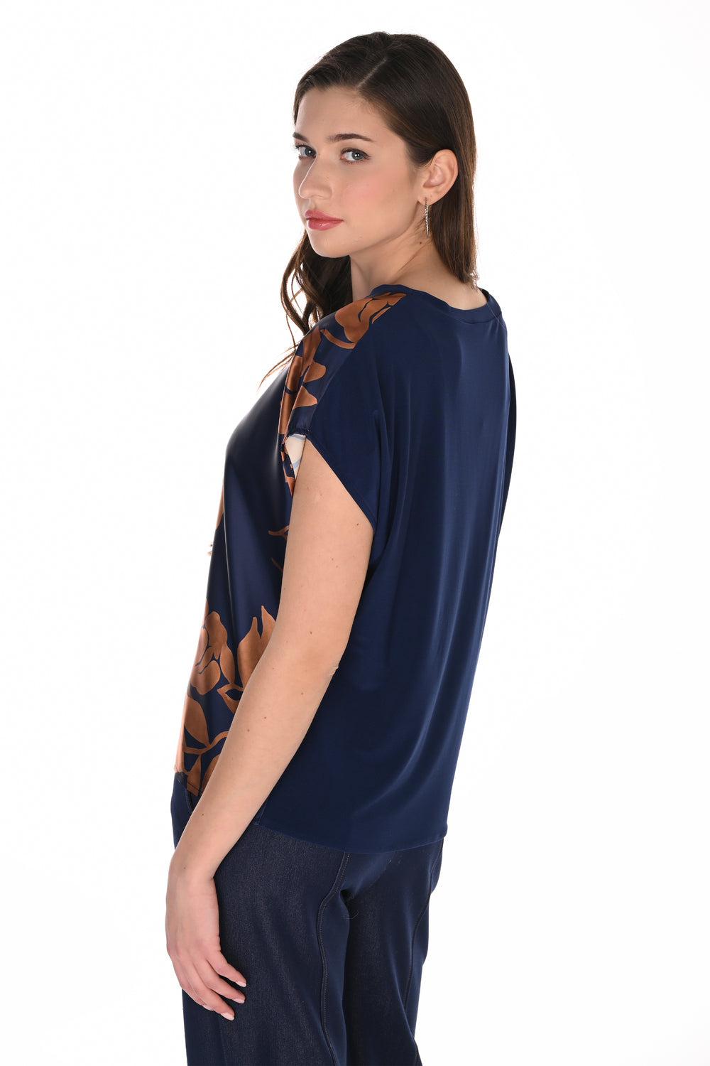 A woman modeling a navy blue short-sleeve top with brown and beige floral patterns on the shoulders and sides, paired with matching navy pants, against a solid white background.