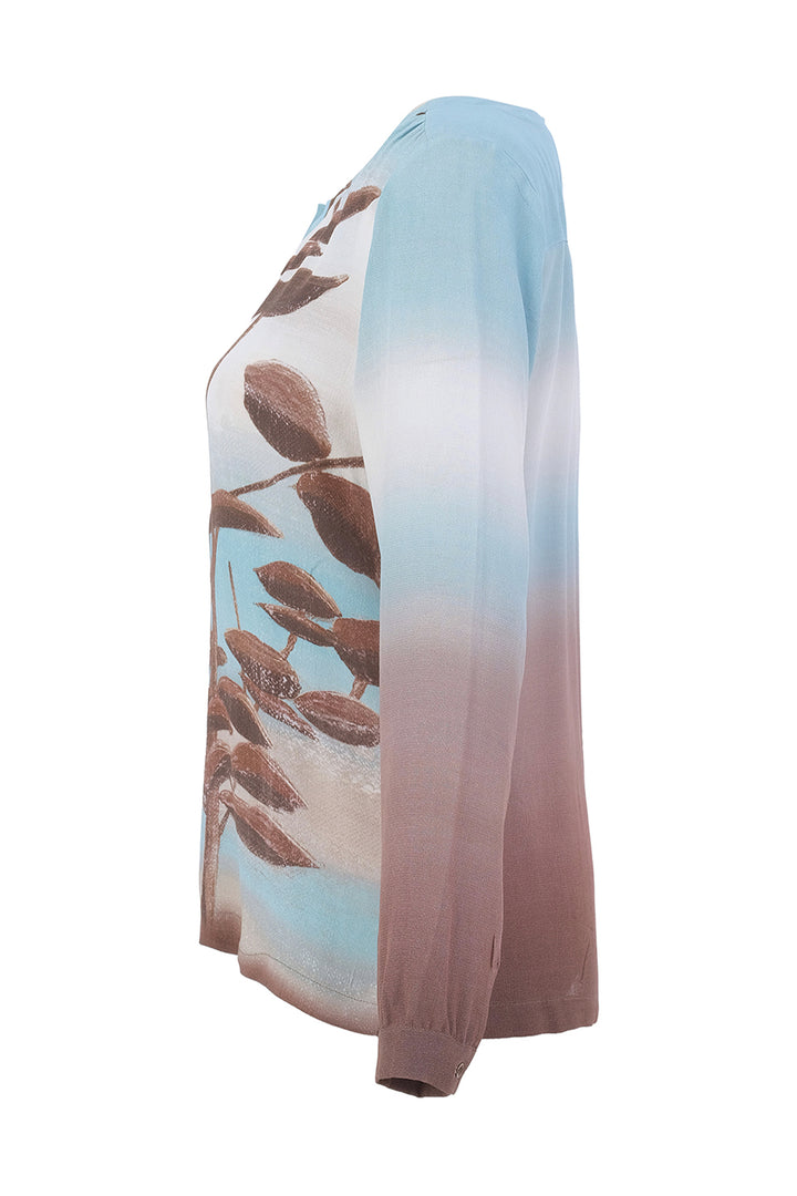 A long-sleeve top with a vertical ombré gradient transitioning from light blue at the top to white in the middle and dusty rose pink at the bottom, featuring a brown leaf branch graphic printed on the front.