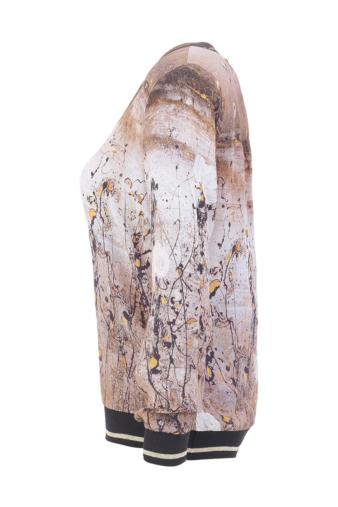 A long-sleeve knit top shown from the side profile against a white background, featuring an abstract paint-splatter print in beige, brown, black, and yellow, with black and white striped ribbed cuffs.