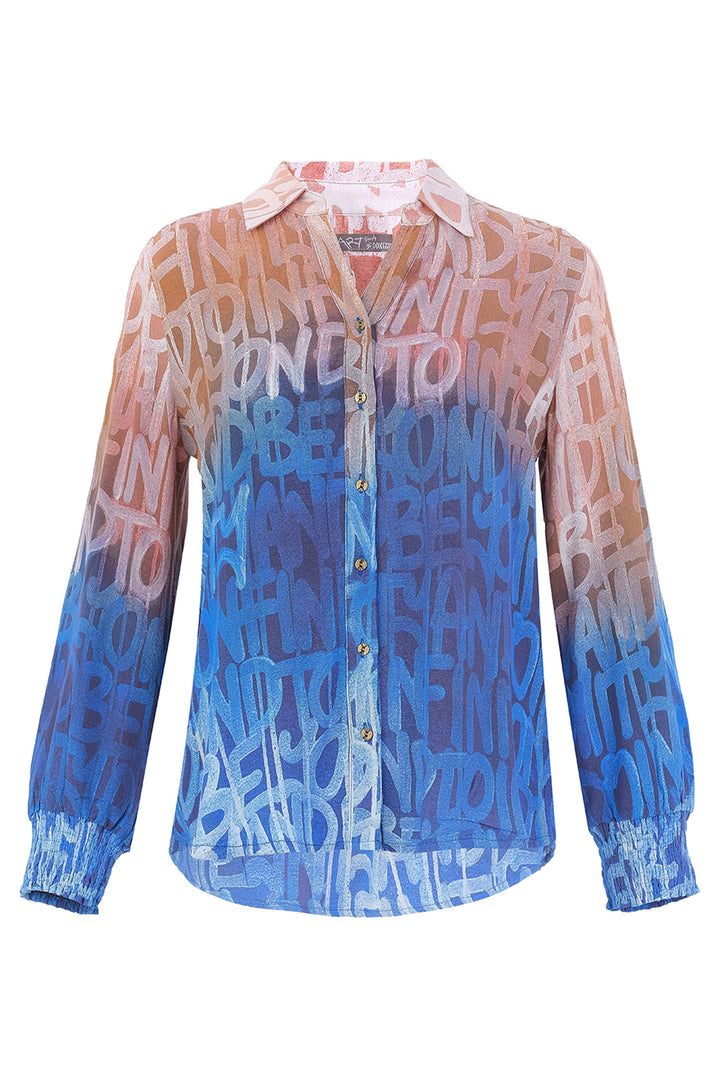 A long-sleeve blouse with an allover repeating text pattern in white over a blue-to-peach gradient, shown on a white background.