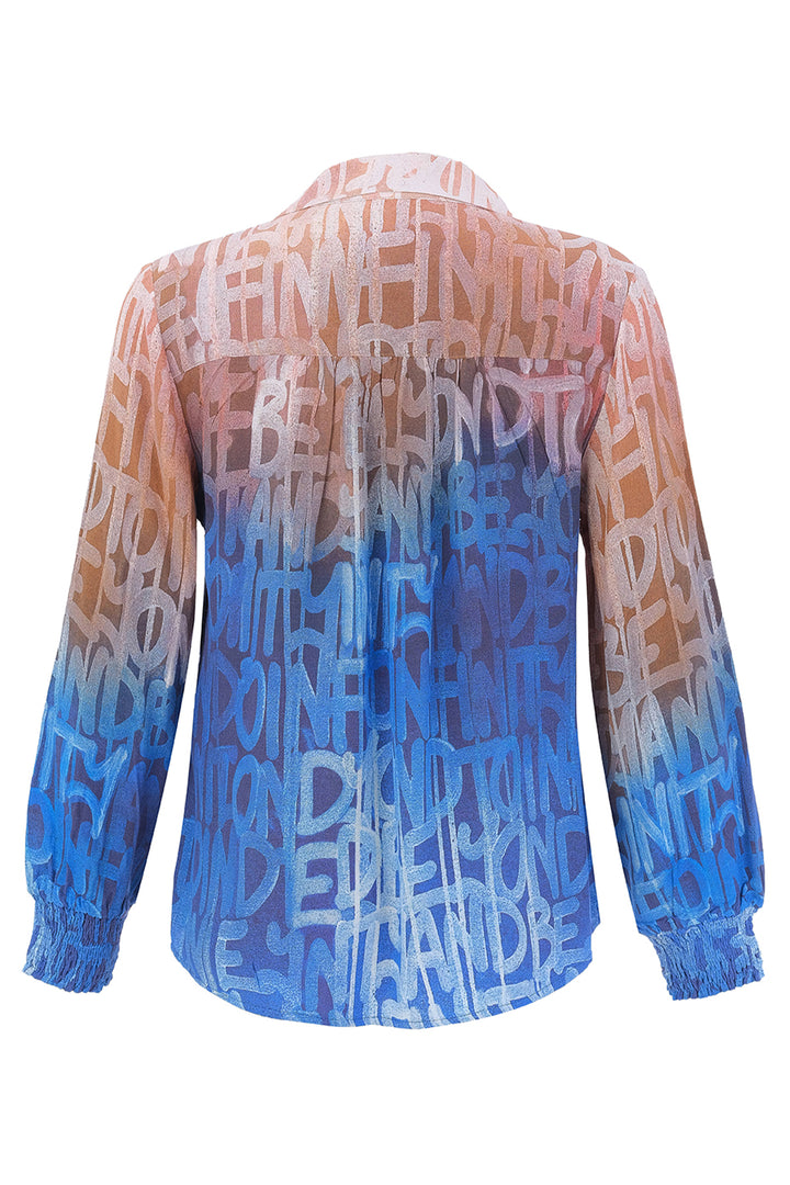 A long-sleeve button-up blouse shown from the back, featuring a gradient color scheme transitioning from peach-orange at the top to light pink and vibrant blue at the bottom. The entire garment is covered in a repeating abstract pattern of stylized text.