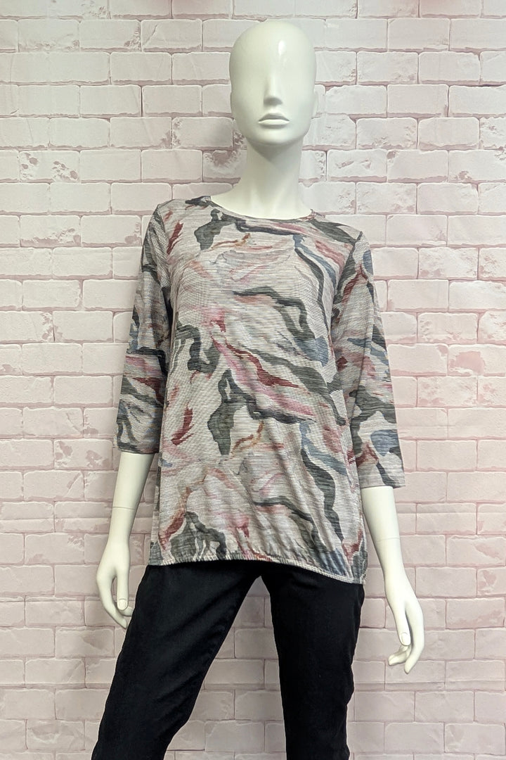 A female mannequin wearing a light grey and green printed t-shirt.