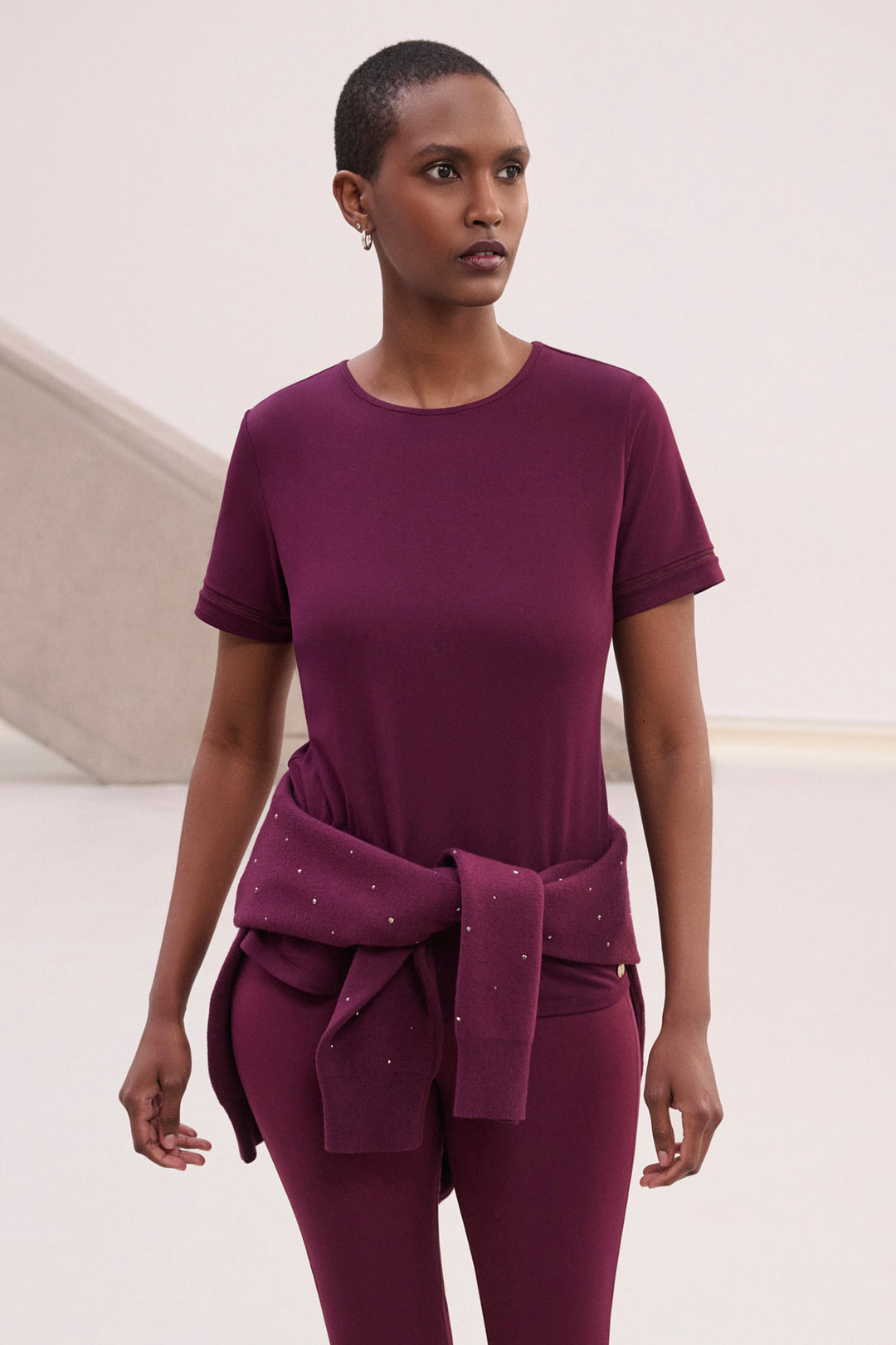 A woman modelling a burgundy short sleeve t-shirt.