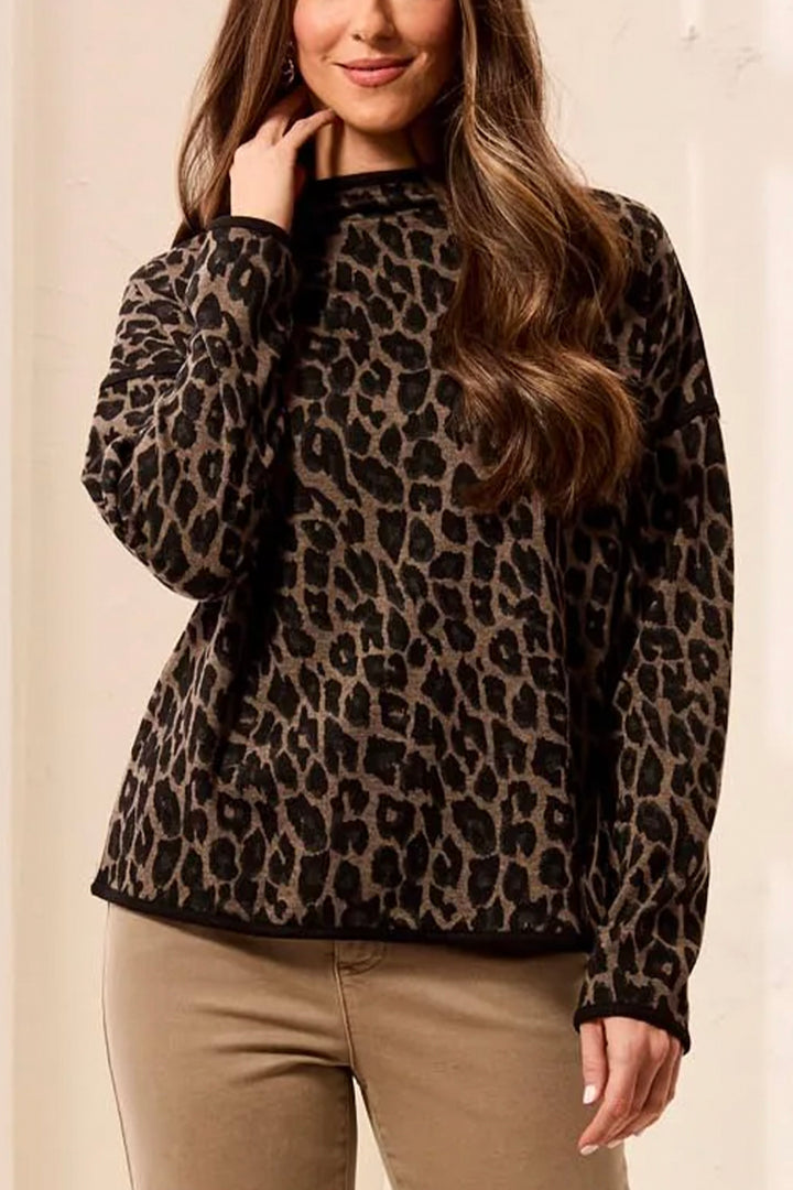 A woman wearing a boxy animal print long sleeve sweater. 