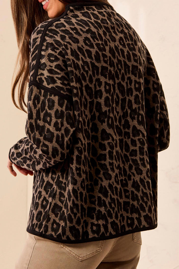 A woman shown from the back wearing a boxy animal print long sleeve sweater. 