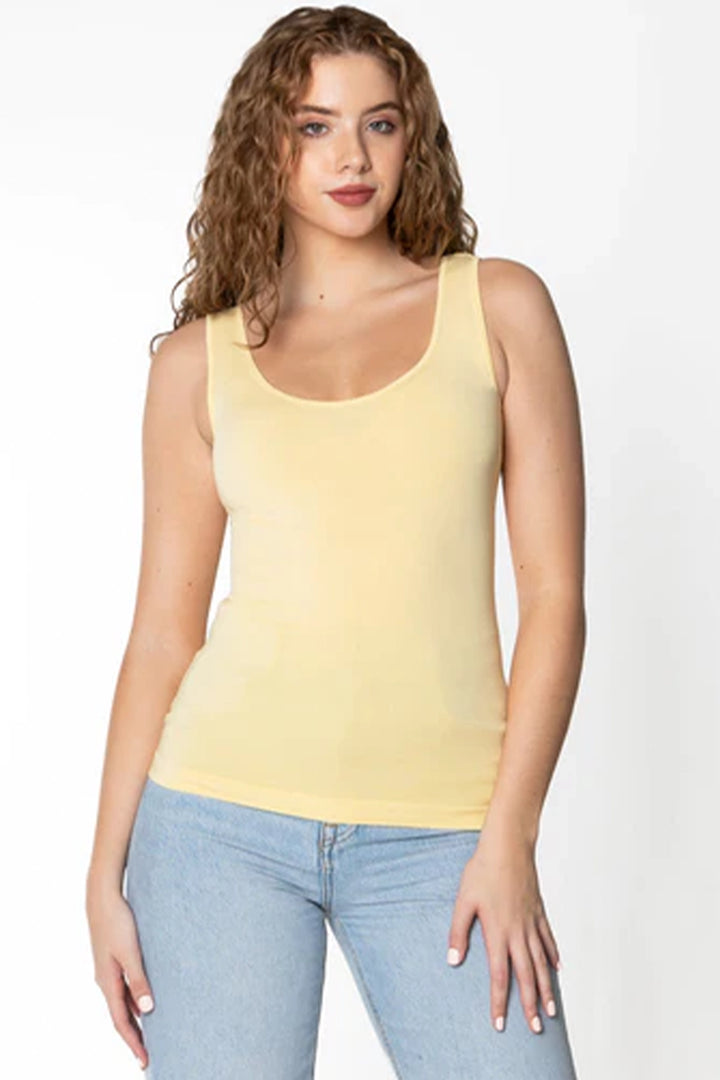 Woman wearing a butter yellow tank top on white background