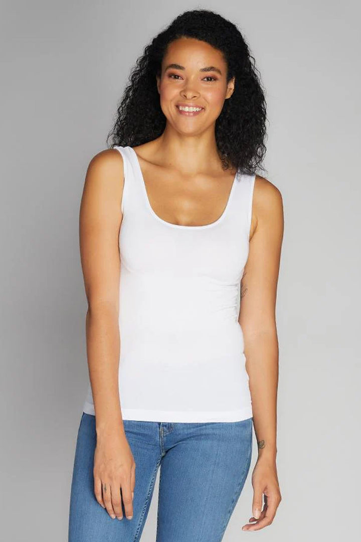 Woman wearing a white tank top on white background