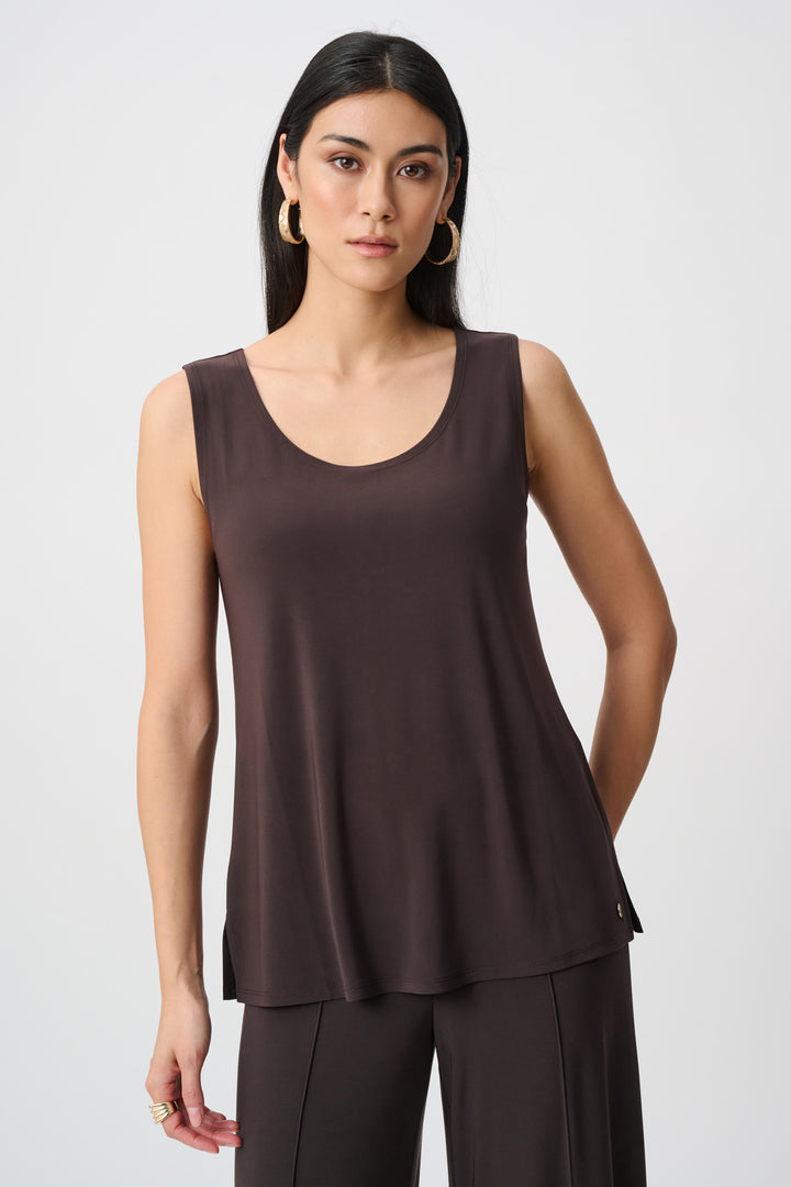 Woman wearing a brown sleeveless top and pants on a white background