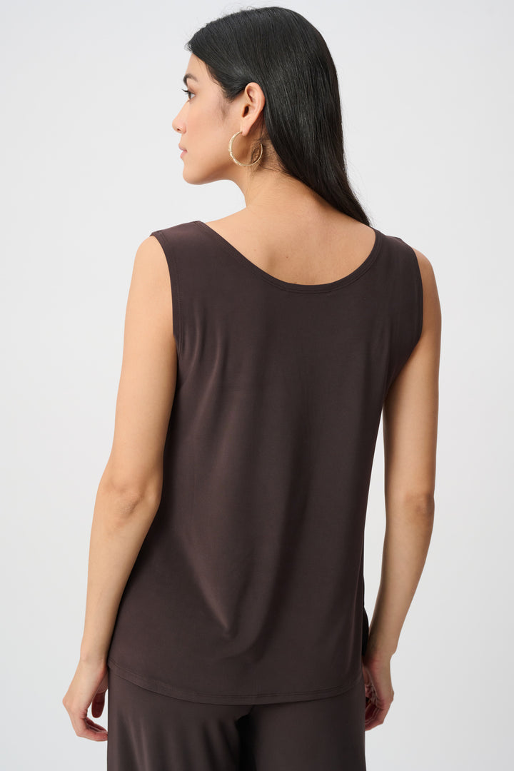 Woman wearing a brown sleeveless top against a white background