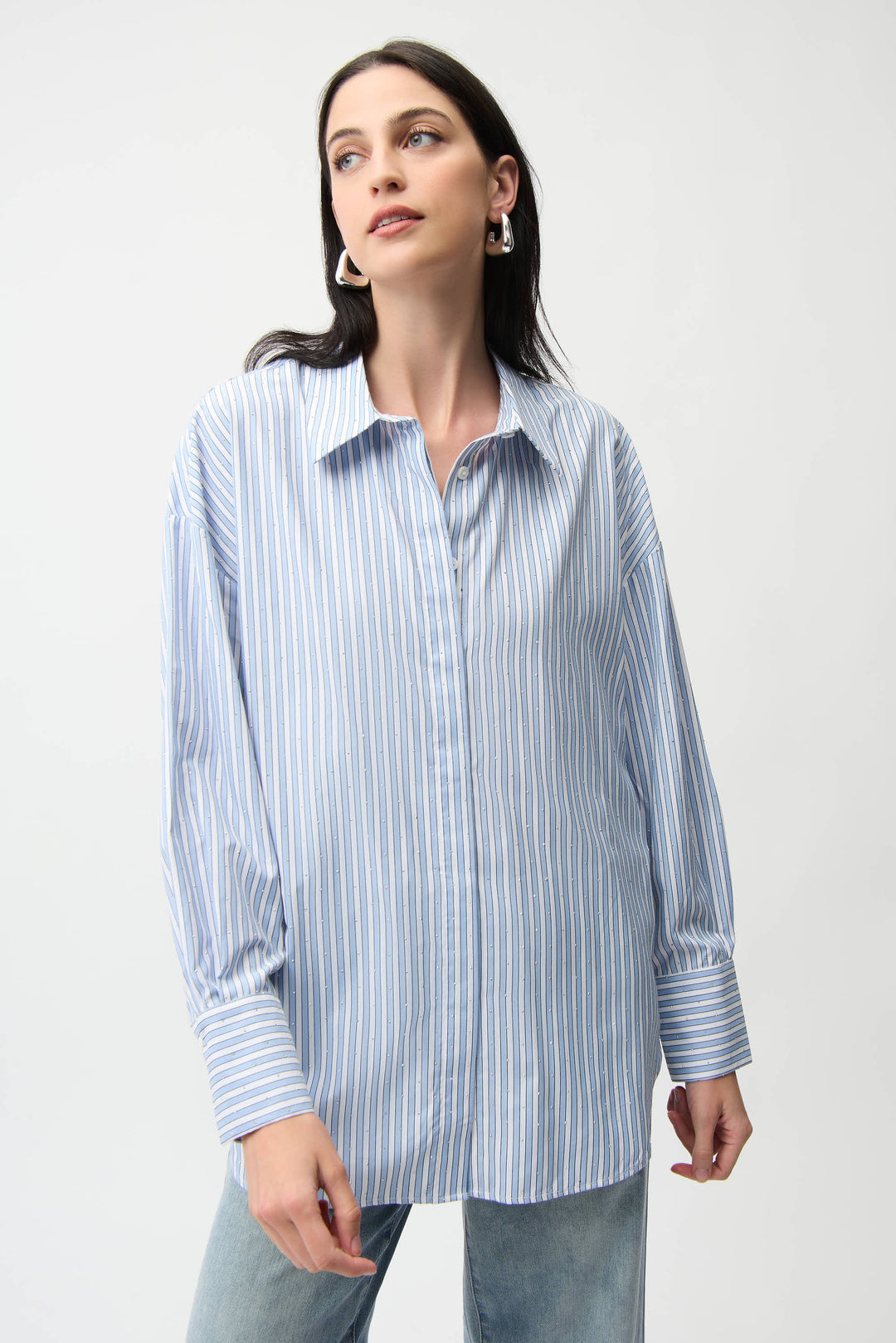 Woman wearing a blue and white striped shirt against a plain background