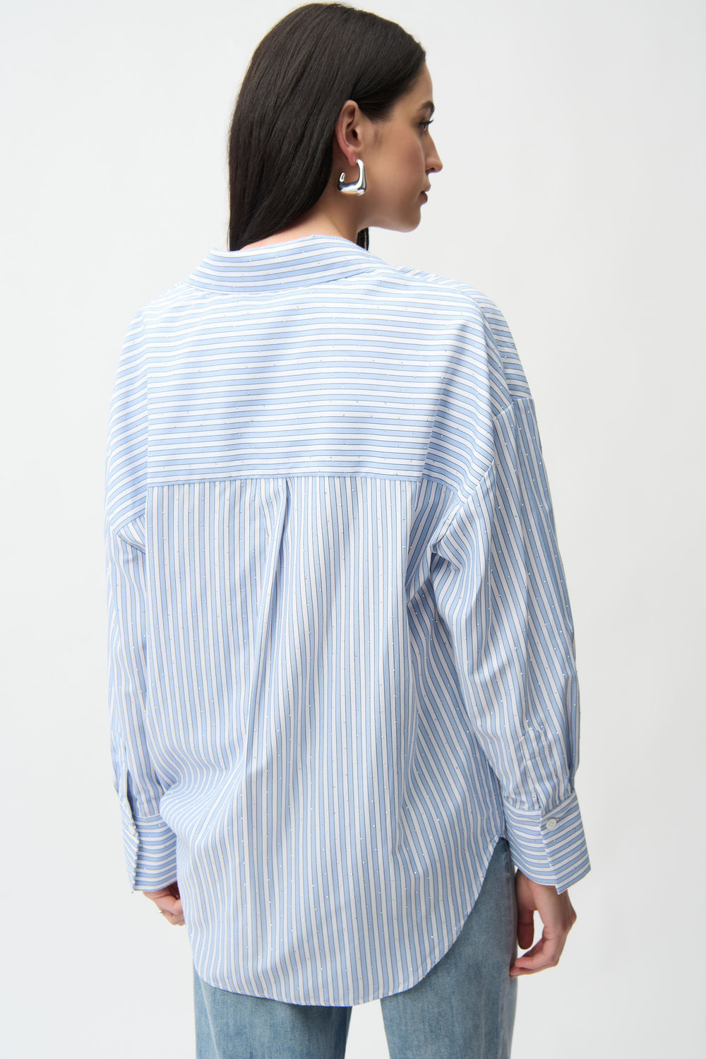 Person wearing a blue and white striped shirt on a plain background