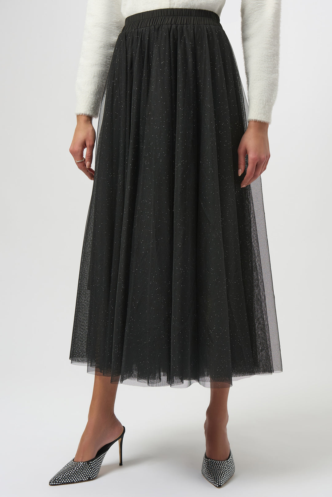 Black tulle skirt worn by a person on a white background
