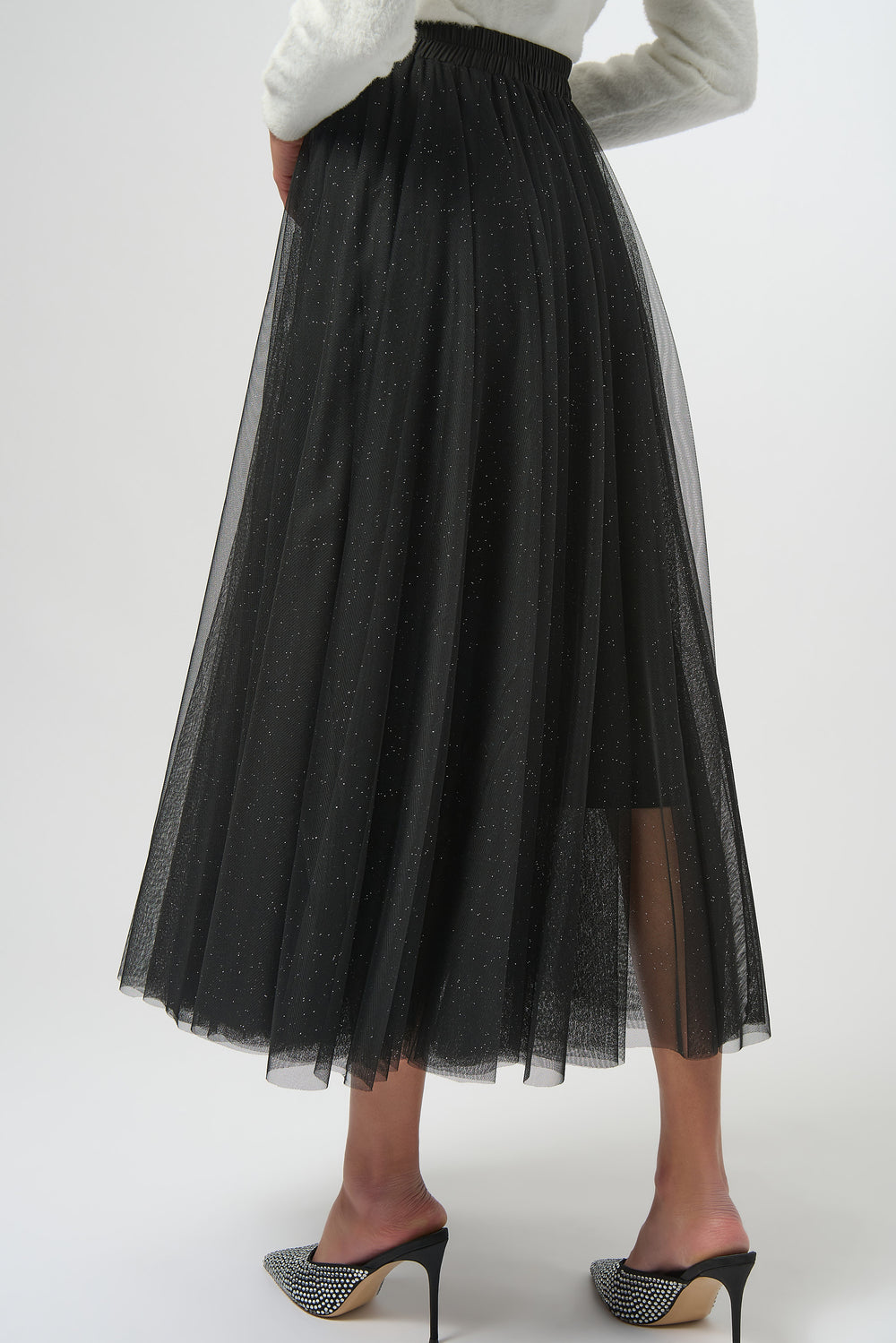 Black tulle skirt worn by a person on a white background