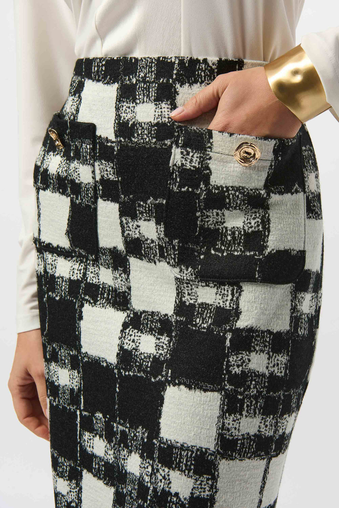 Black and white checkered mini skirt with gold buttons worn by a person.