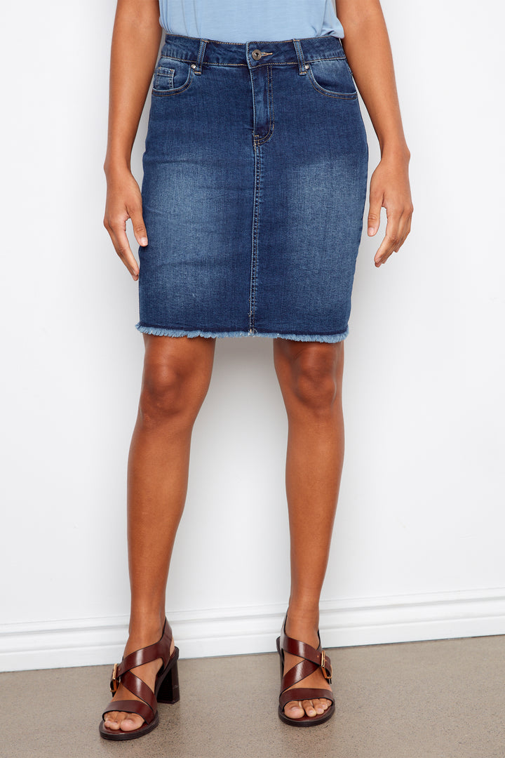 Person wearing a blue denim skirt against a white background