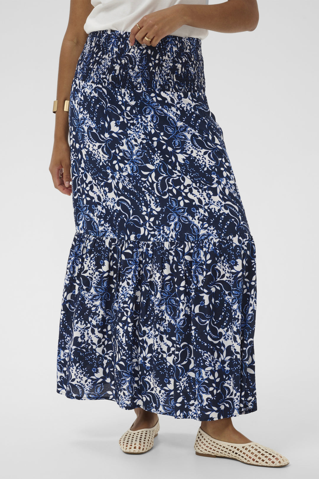 Person wearing a blue floral long skirt on a white background