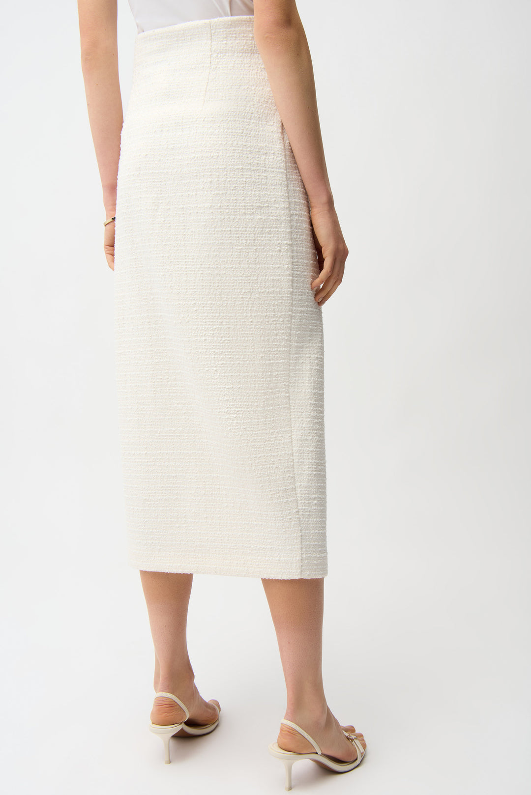 Person wearing a white textured skirt on a plain background