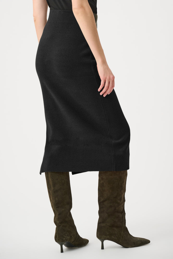 Person wearing a black dress and brown knee-high boots on a white background