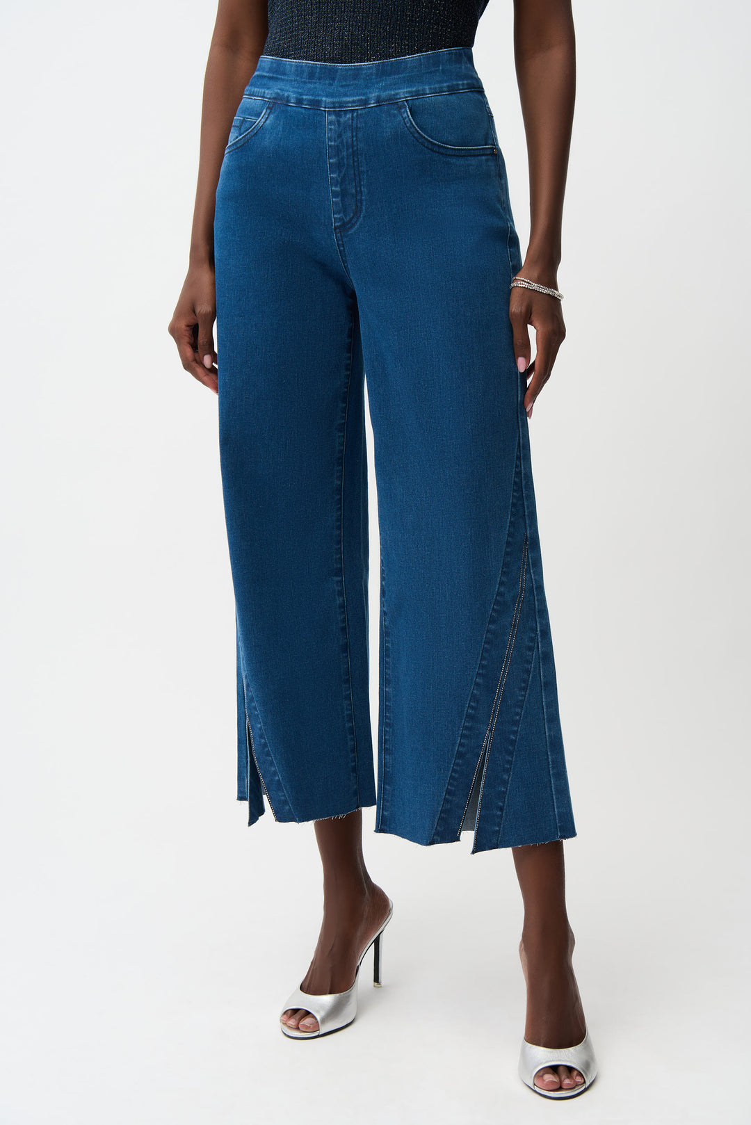 Blue denim wide-leg pants with rhinestones worn by a person on a white background
