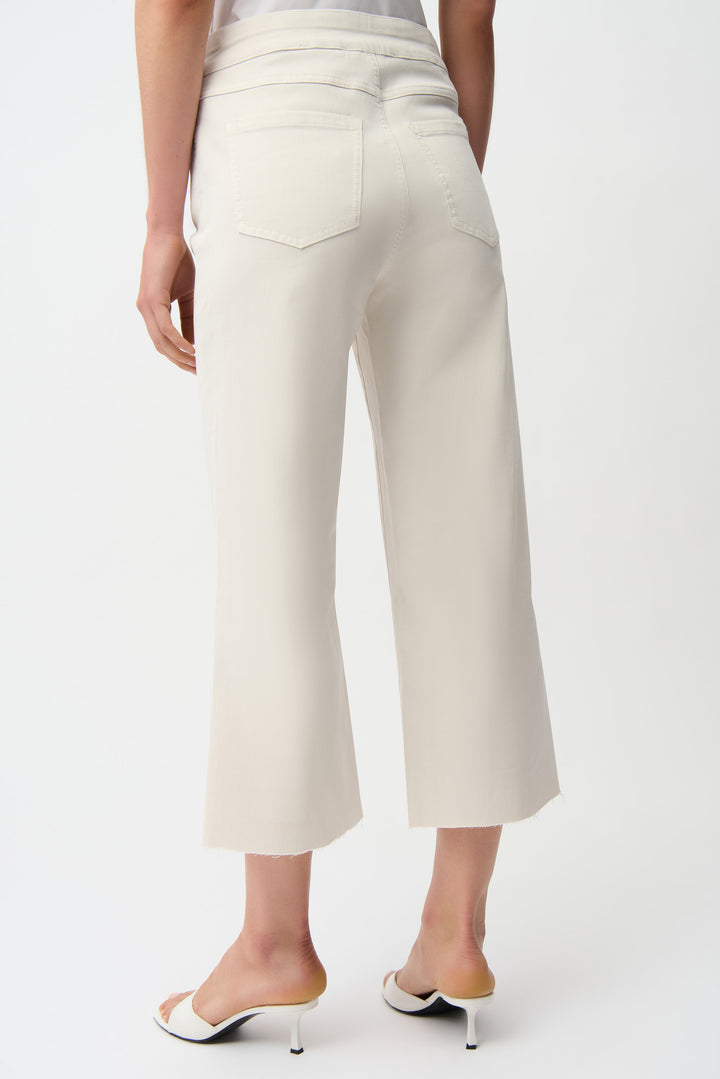 White capri pants worn by a person on a white background