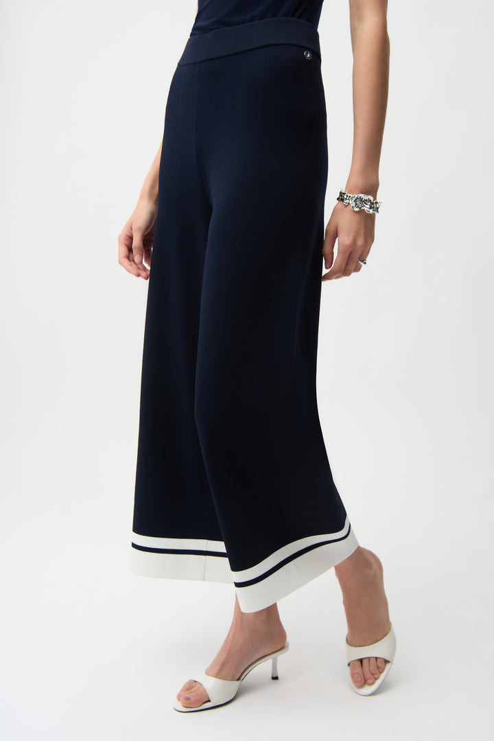 Navy wide-leg pants with white trim hems worn by a person on a white background