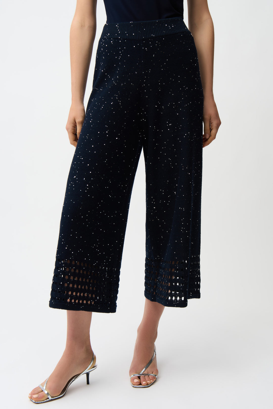 Navy blue wide leg pants with cut-out crochet details and sparkles on a white background