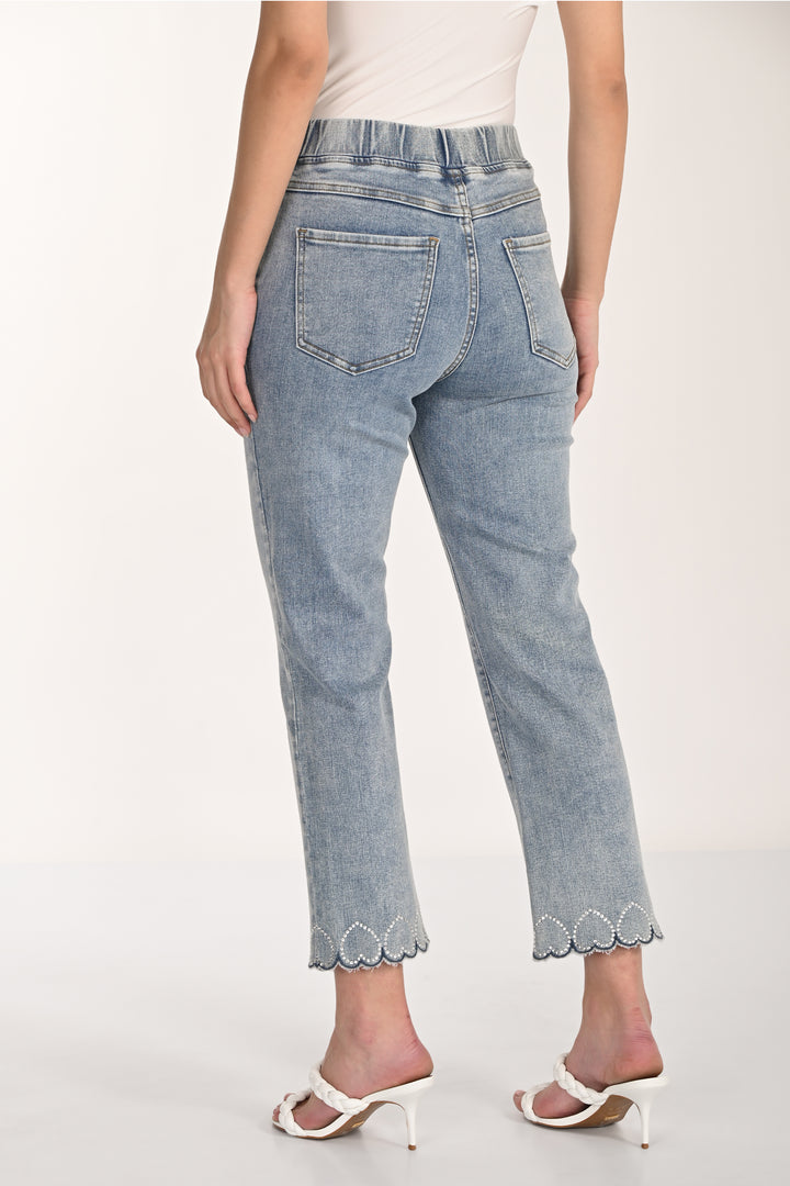 Light blue jeans with scalloped hem with hearts worn by a person on a white background