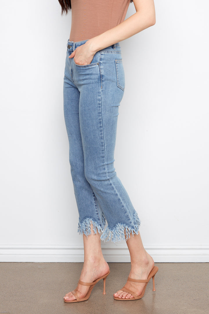 Person wearing light blue jeans with a white background