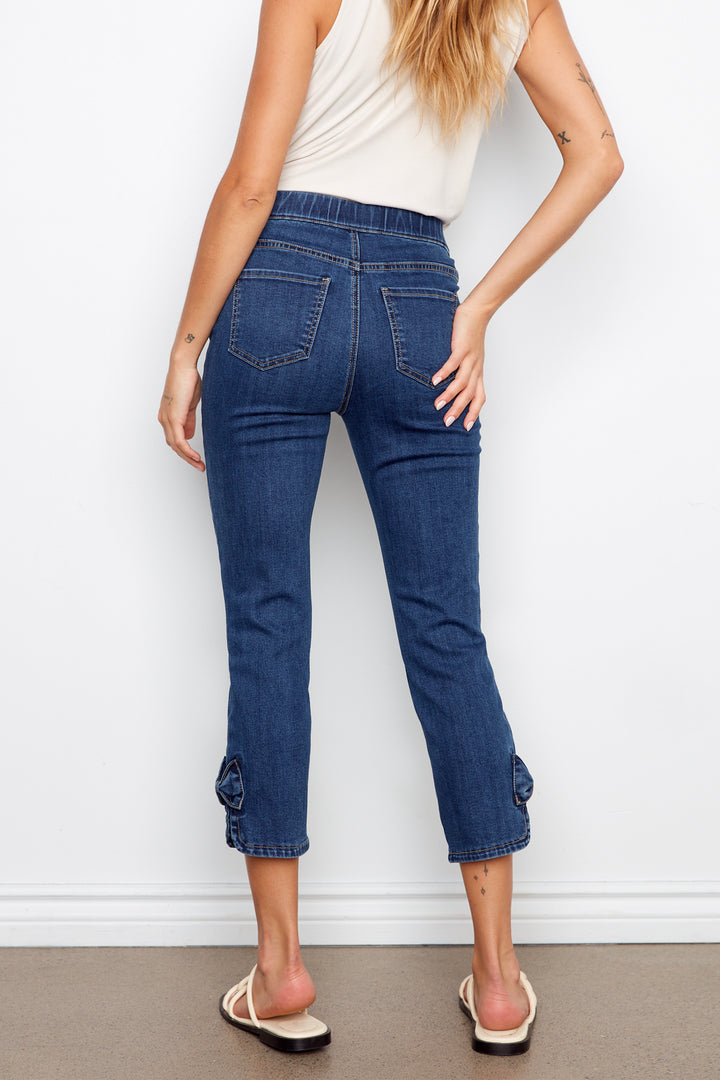 Person wearing blue jeans against a white wall