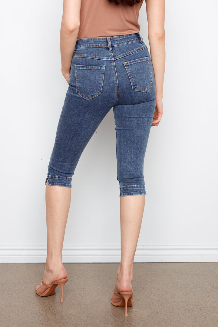 Person wearing blue denim capri pants against a white background
