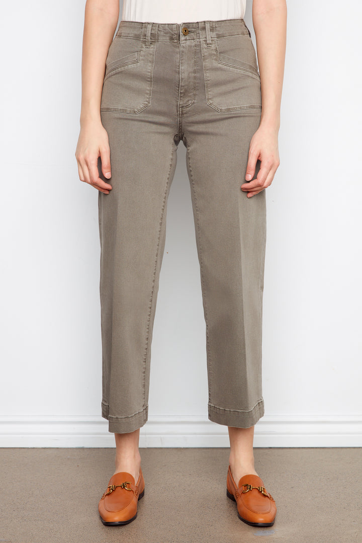 Person wearing brown pants and brown shoes on a plain background