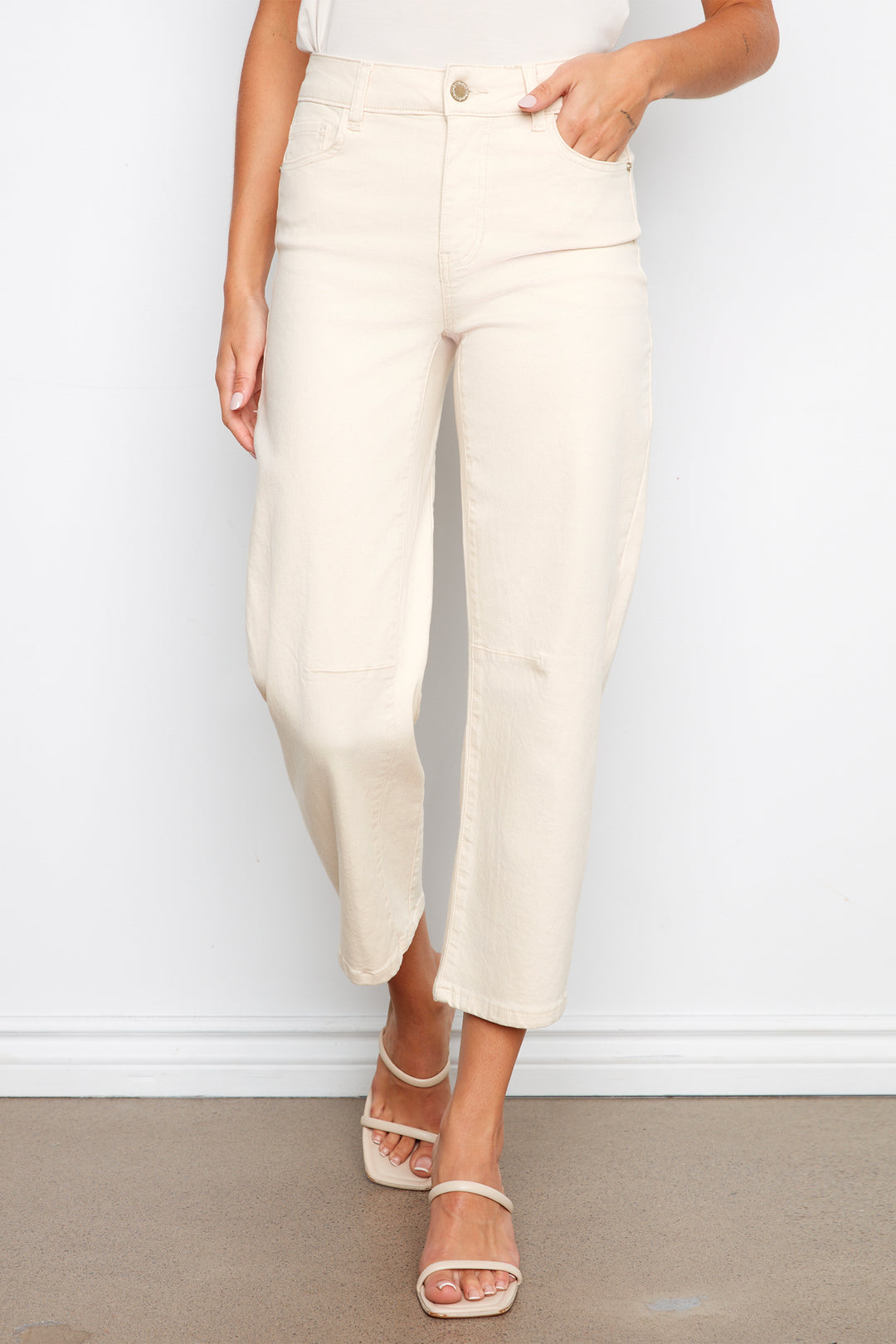 Person wearing white pants against a plain background