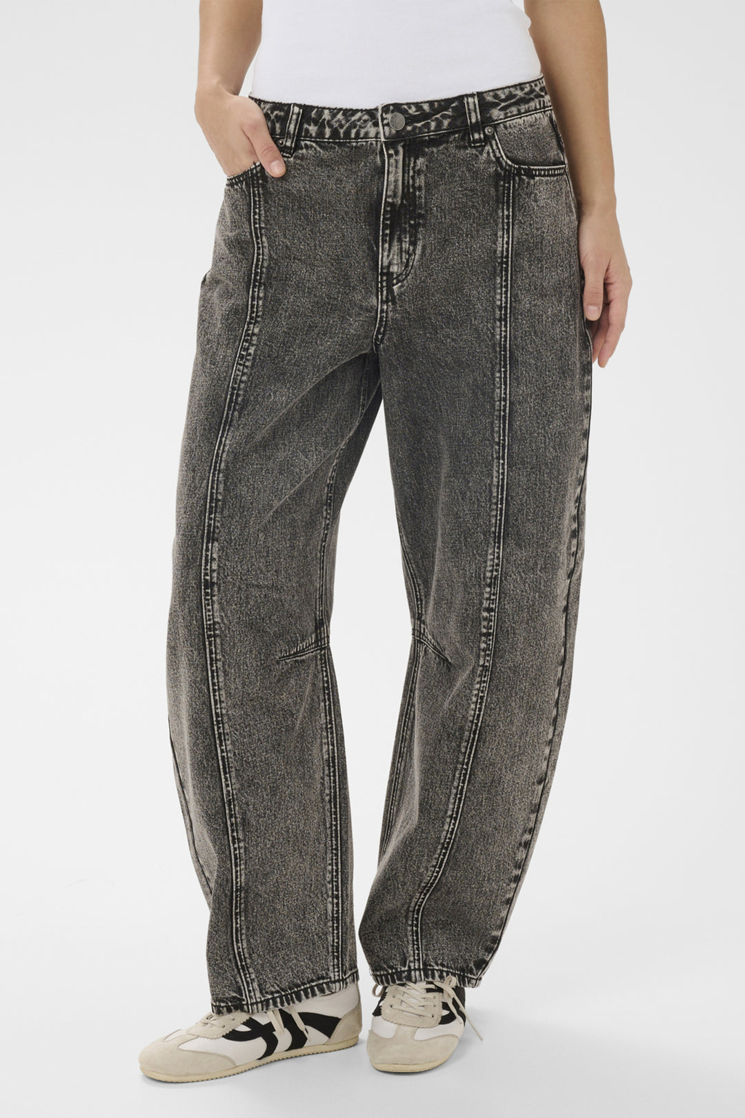 Person wearing black distressed jeans on a white background