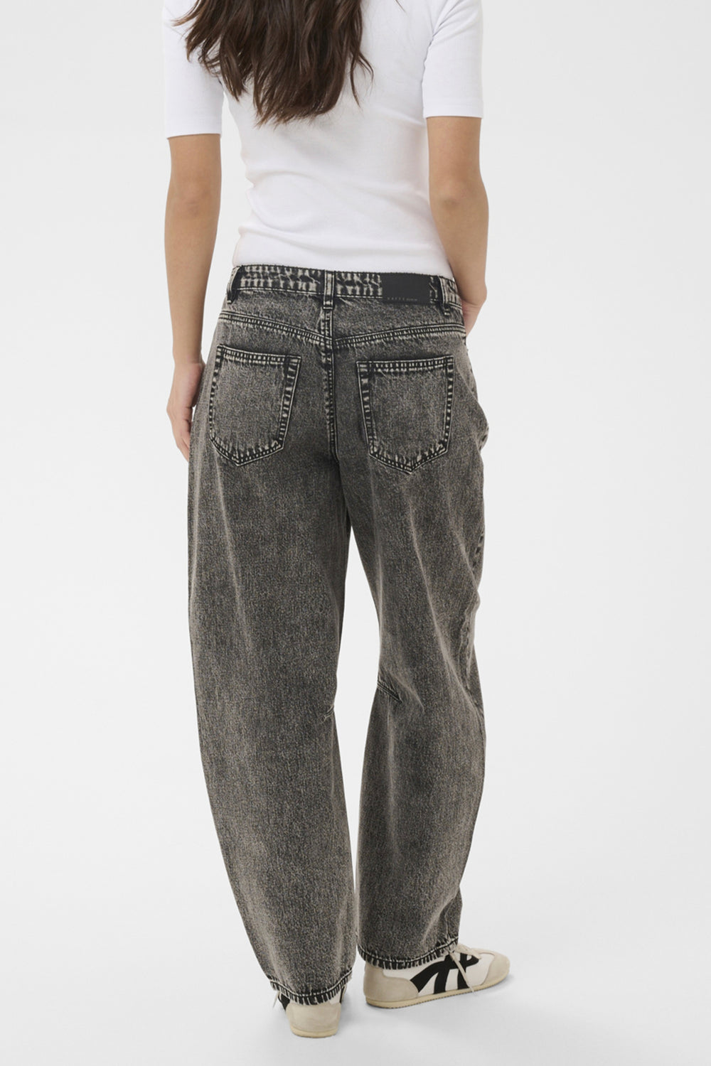 Person wearing gray jeans and a white shirt on a white background