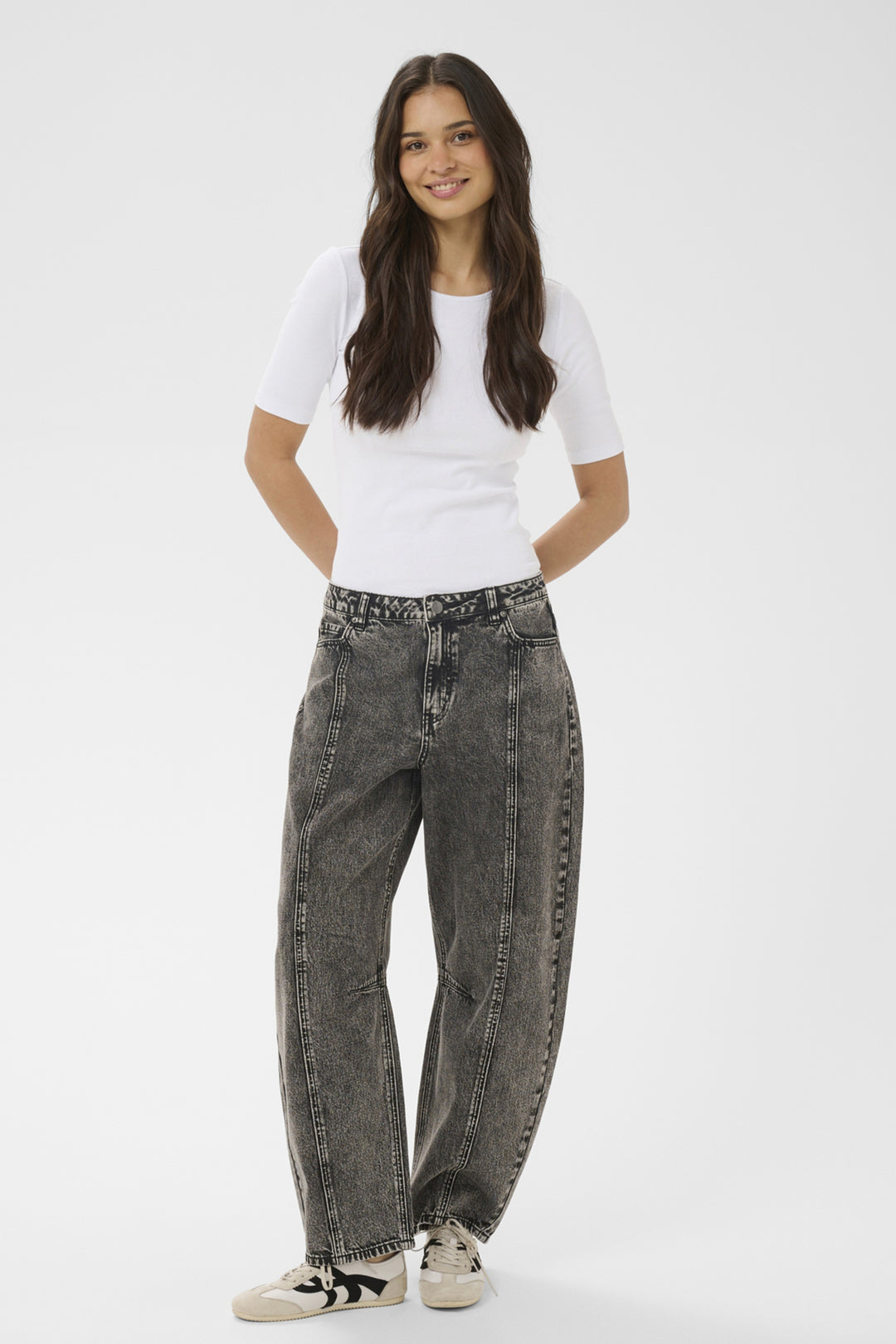 Woman wearing a white t-shirt and gray jeans on a white background
