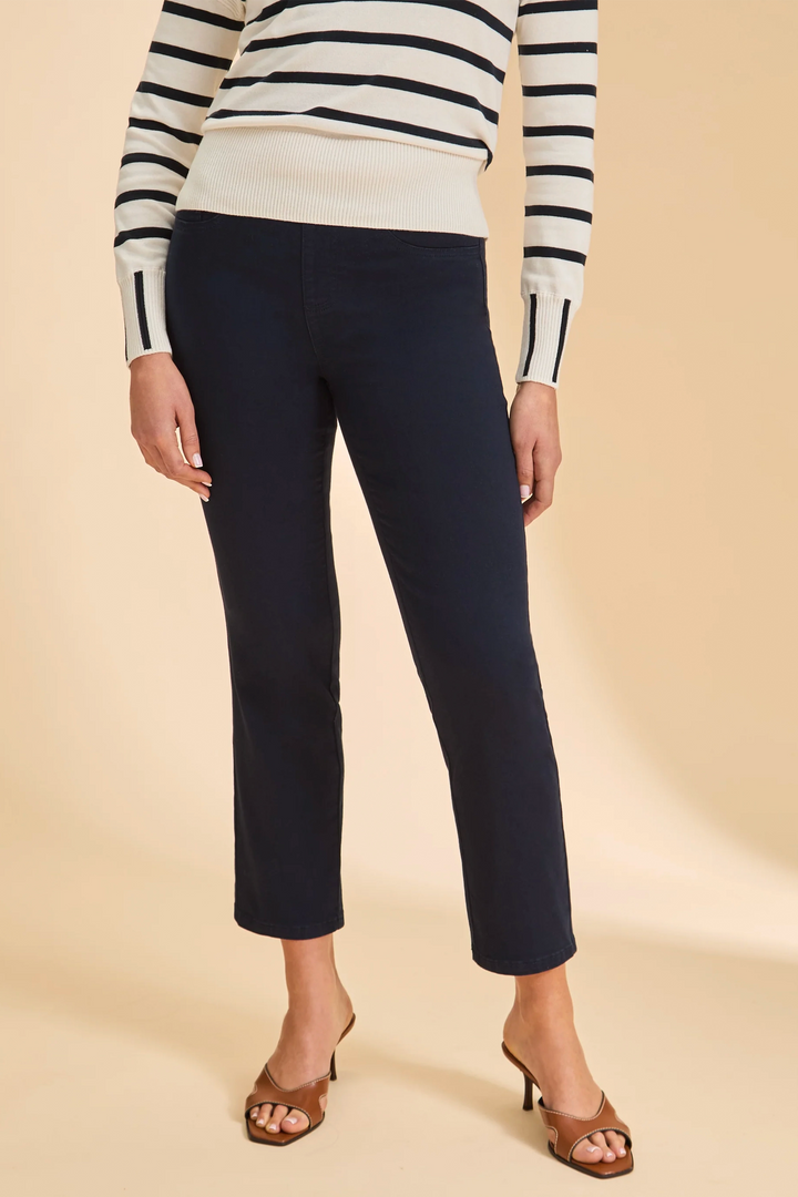 Person wearing navy pants and a striped sweater on a beige background