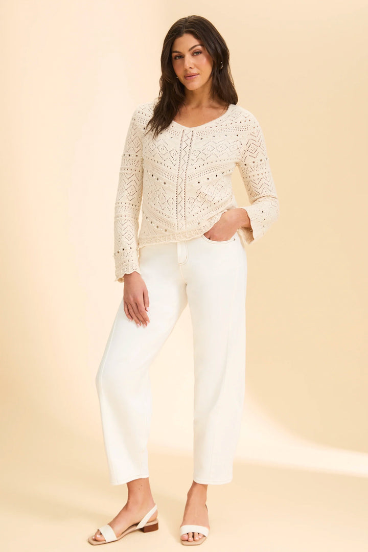 Woman wearing a white girlfriend jeans against a beige background