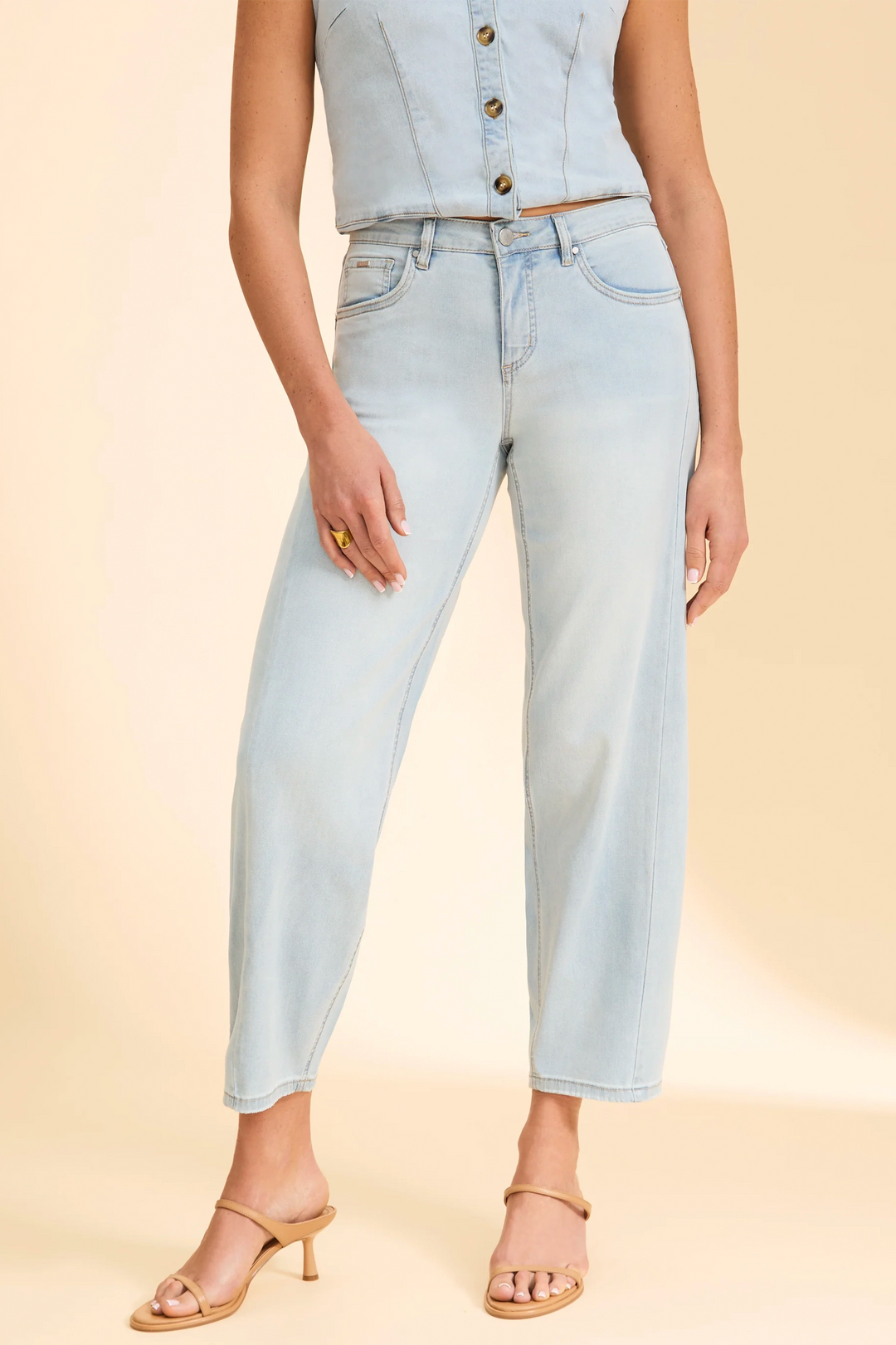 Light blue jeans worn by a person on a beige background